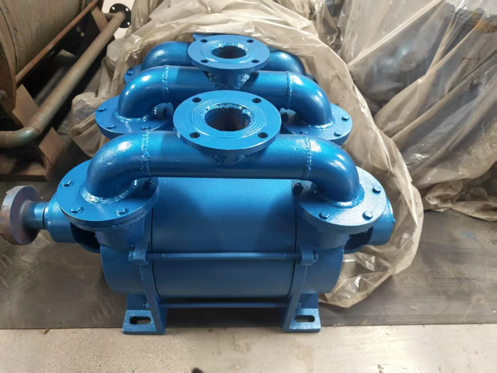 Blue industrial water-ring vacuum pump with flanged connections, shown as general replacement-review equipment context; not a customer-specific shared-header layout or performance result.
